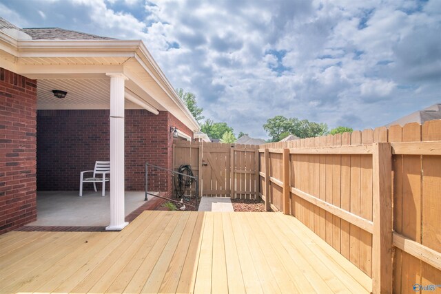 deck with a fenced backyard and a gate
