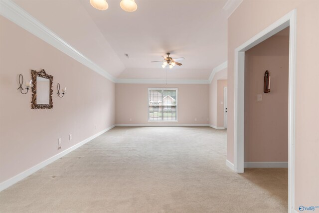 spare room with light colored carpet, a ceiling fan, crown molding, and baseboards