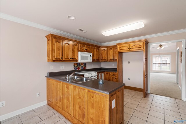 kitchen with white microwave, a peninsula, light tile patterned floors, brown cabinets, and dark countertops