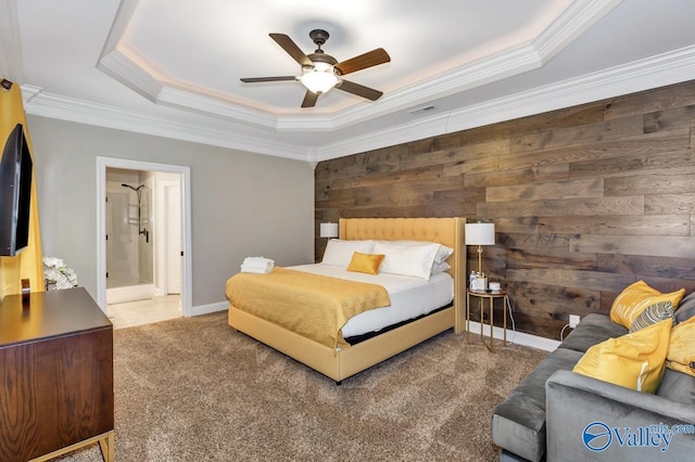 carpeted bedroom with visible vents, baseboards, ceiling fan, ornamental molding, and a raised ceiling