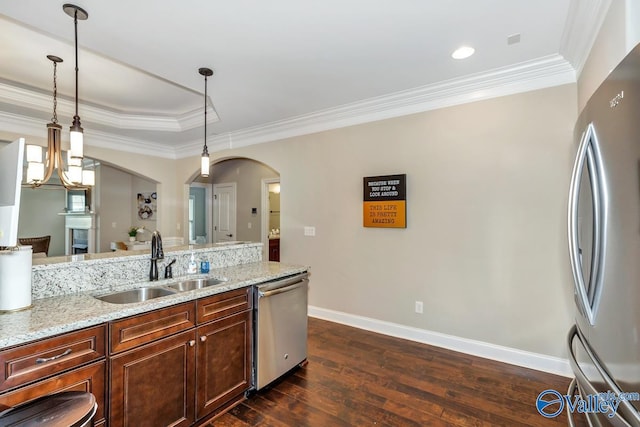 kitchen with light stone countertops, dark wood-style floors, appliances with stainless steel finishes, arched walkways, and a sink