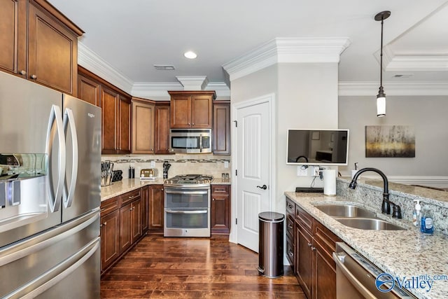 kitchen featuring a sink, light stone countertops, decorative backsplash, appliances with stainless steel finishes, and dark wood-style flooring