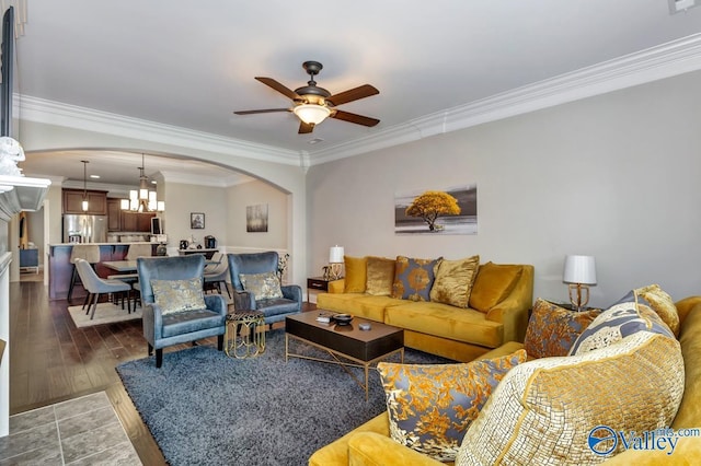 living area featuring wood finished floors, arched walkways, ceiling fan, and crown molding