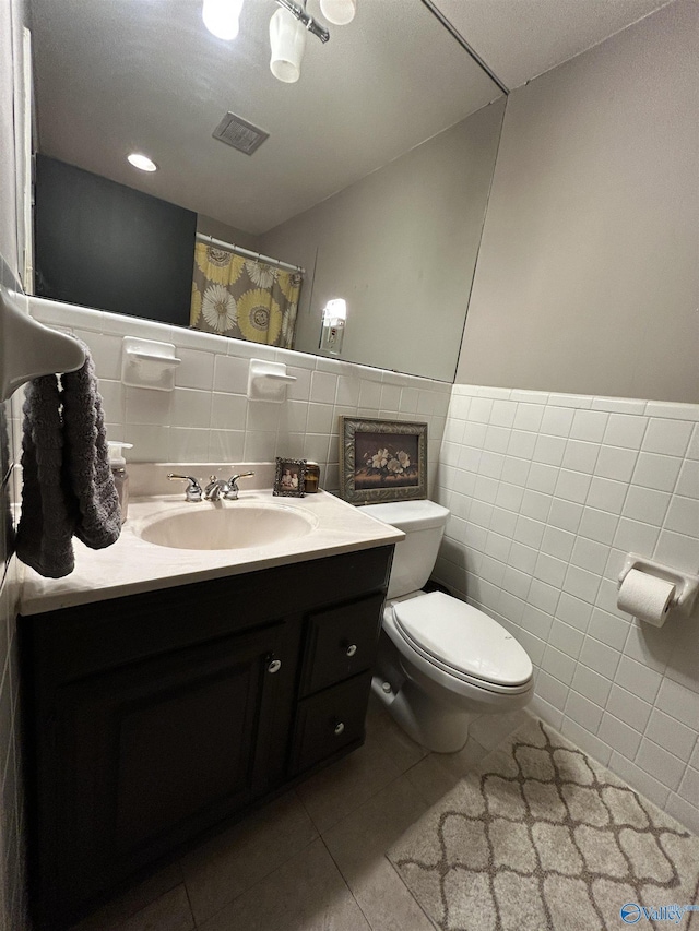 bathroom featuring tile walls, vanity, tile patterned flooring, and toilet