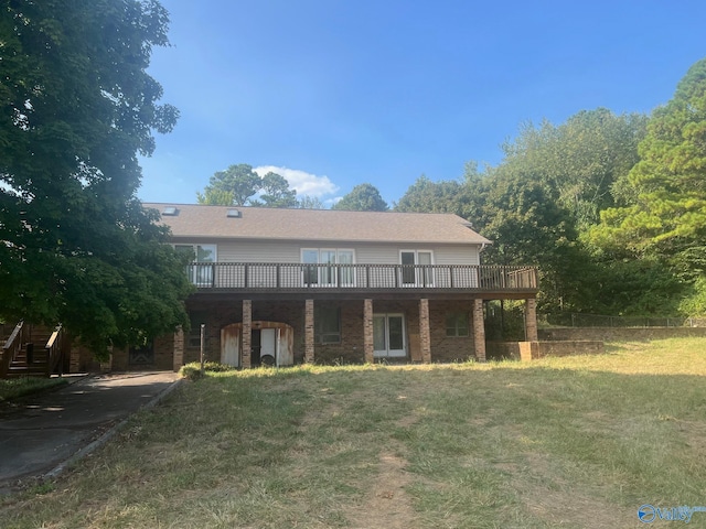 view of front of house with a wooden deck, a shed, and a front lawn