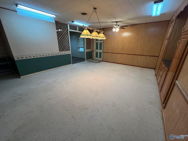 basement with light carpet and wooden walls