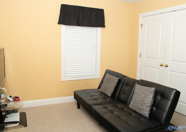 living area featuring carpet flooring and baseboards