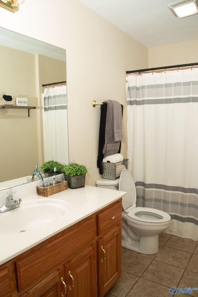 full bathroom with toilet, tile patterned floors, and vanity
