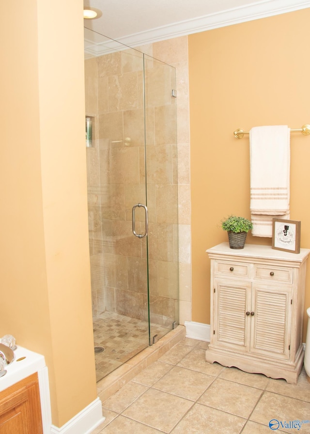 bathroom with a stall shower, crown molding, baseboards, and tile patterned floors