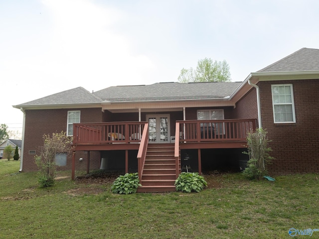 rear view of house featuring a lawn, brick siding, stairs, a shingled roof, and a deck