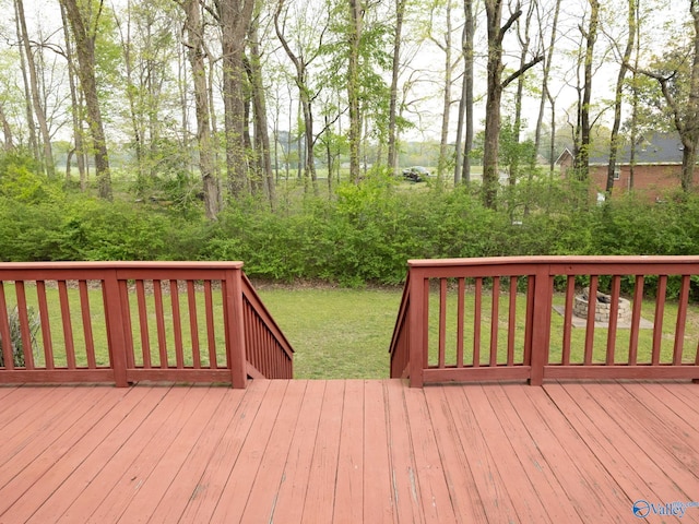 wooden deck featuring a lawn