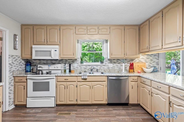 kitchen with dark wood-style flooring, white appliances, backsplash, and a sink