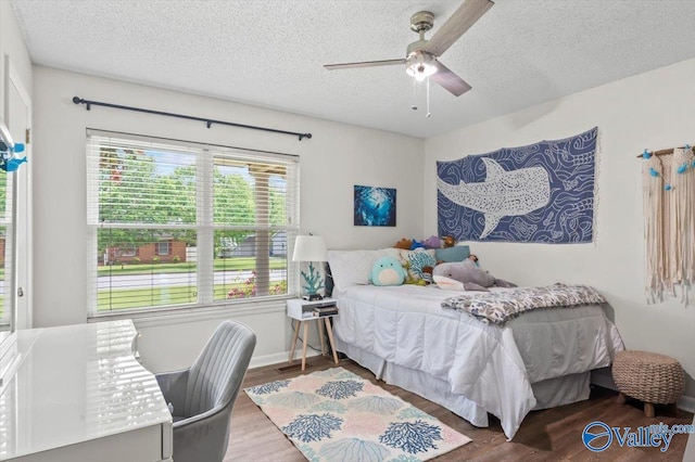 bedroom with wood finished floors, ceiling fan, and a textured ceiling