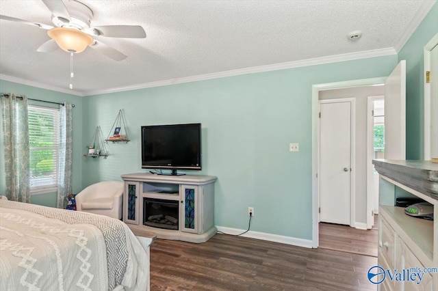 bedroom with a ceiling fan, baseboards, ornamental molding, a textured ceiling, and wood finished floors