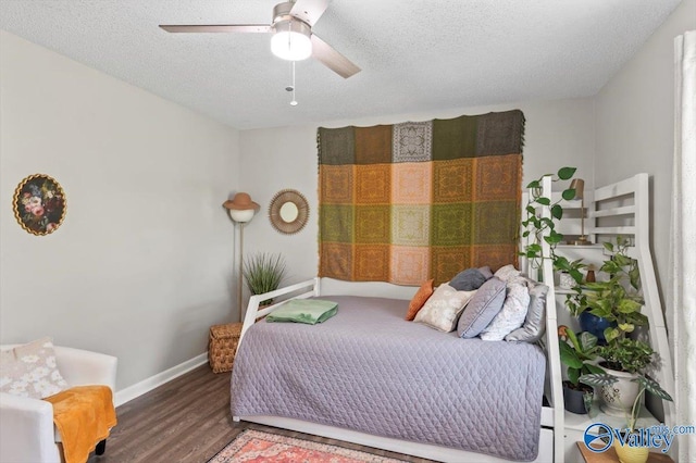 bedroom with a textured ceiling, wood finished floors, ceiling fan, and baseboards