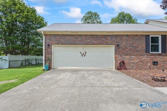 garage with driveway and fence