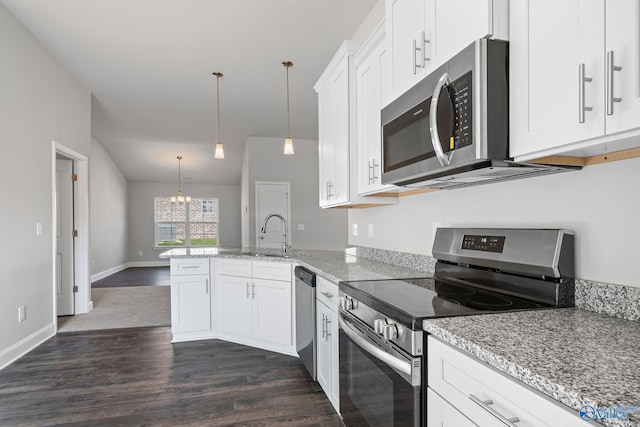 kitchen featuring appliances with stainless steel finishes, dark wood-style flooring, a sink, and a peninsula