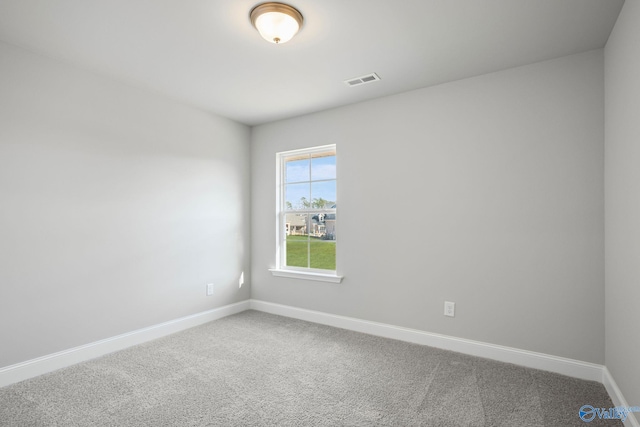 spare room with baseboards, visible vents, and carpet flooring