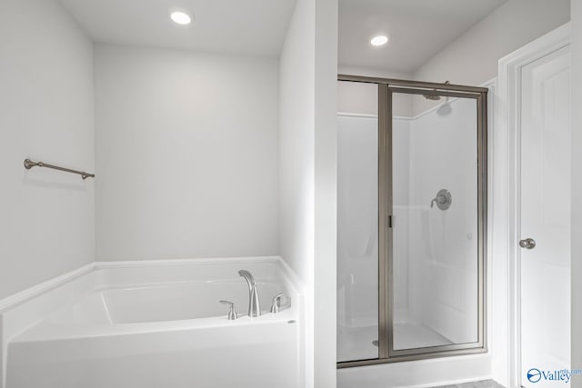 bathroom with a stall shower, a garden tub, and recessed lighting