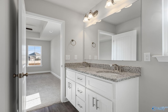 bathroom with a sink, baseboards, and double vanity