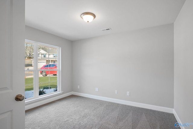 empty room with plenty of natural light, carpet, visible vents, and baseboards