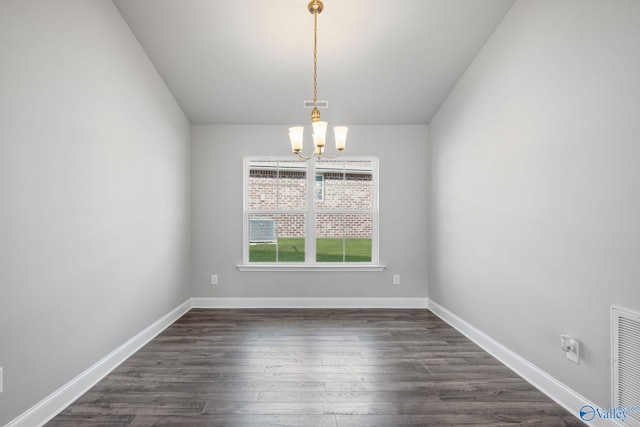 empty room with dark wood-style floors, visible vents, a notable chandelier, and baseboards