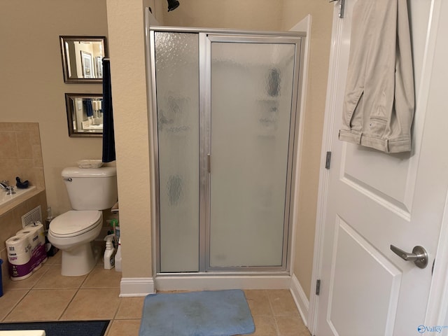 bathroom with toilet, a shower with shower door, and tile patterned flooring