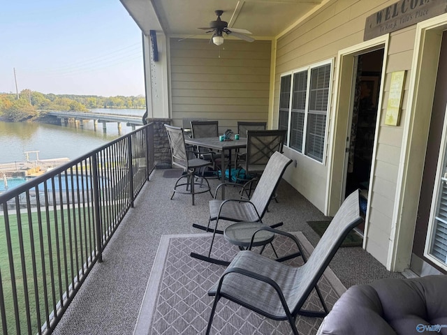 balcony featuring ceiling fan and a water view