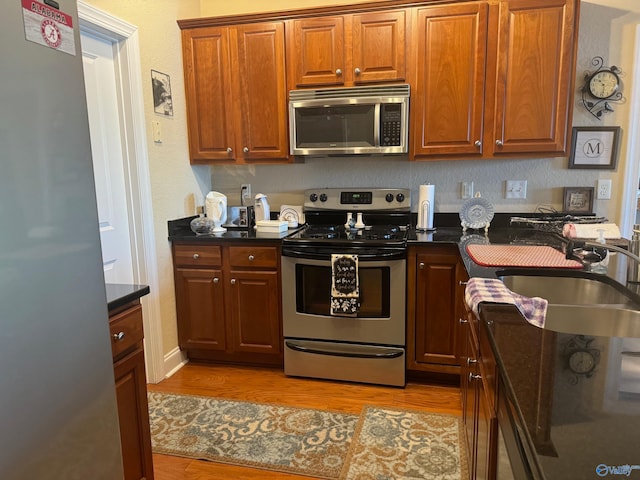 kitchen featuring light wood-type flooring, sink, and stainless steel appliances