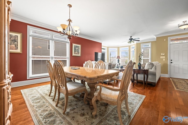 dining area featuring crown molding, baseboards, ceiling fan with notable chandelier, and light wood-type flooring