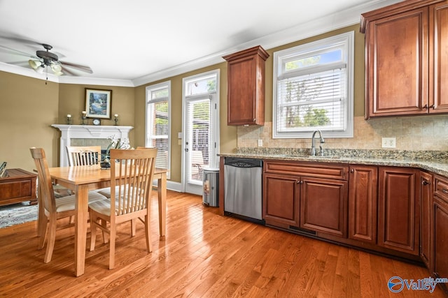 kitchen with decorative backsplash, crown molding, stainless steel dishwasher, light wood-type flooring, and a sink