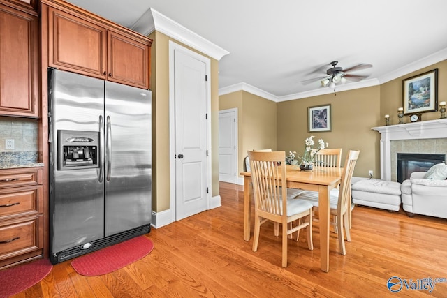 dining area featuring crown molding, light wood-style flooring, and ceiling fan