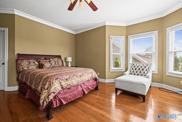 bedroom with baseboards, ceiling fan, ornamental molding, and wood finished floors