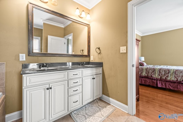 bathroom featuring crown molding, baseboards, and a sink