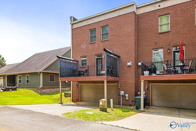 view of property with a garage, a balcony, a front lawn, and brick siding