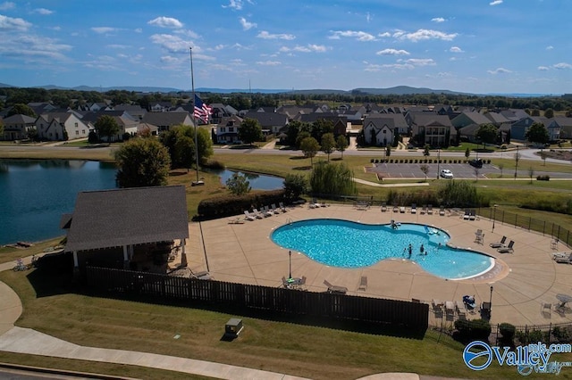 pool featuring a lawn, a patio, fence, and a residential view