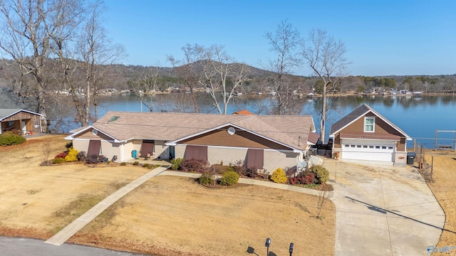 view of front of property featuring a water view, an attached garage, fence, and concrete driveway