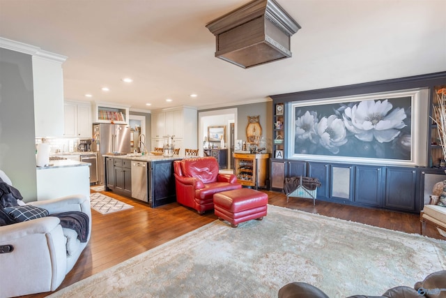 living room with crown molding, dark hardwood / wood-style floors, and sink