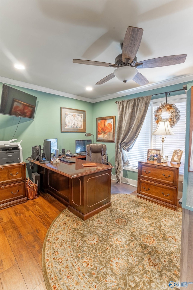 office area with ornamental molding, wood-type flooring, and ceiling fan