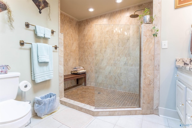 bathroom featuring vanity, a tile shower, tile patterned floors, and toilet