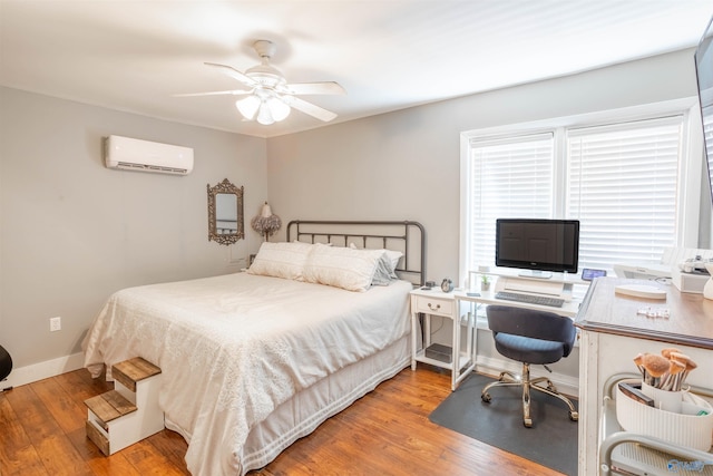 bedroom featuring a wall mounted air conditioner, light hardwood / wood-style flooring, and ceiling fan