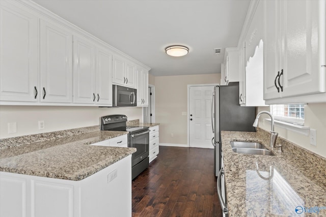 kitchen featuring appliances with stainless steel finishes, sink, white cabinets, light stone countertops, and dark wood-type flooring