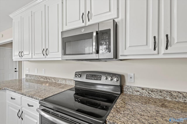 kitchen with stone counters, appliances with stainless steel finishes, and white cabinets