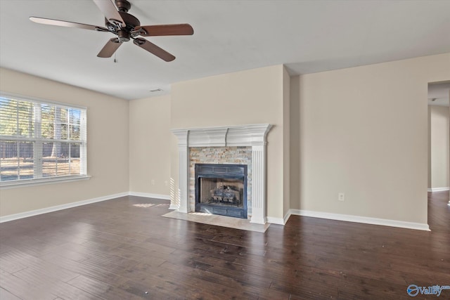 unfurnished living room featuring ceiling fan, a fireplace, and dark hardwood / wood-style flooring