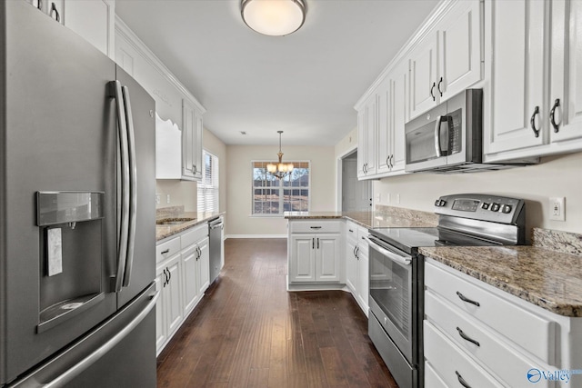 kitchen featuring stainless steel appliances, white cabinetry, hanging light fixtures, and dark hardwood / wood-style flooring