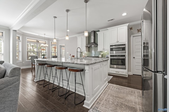 7531 Hadleigh Crst, Owens Cross Roads, AL 35763 - kitchen featuring appliances with stainless steel finishes, wall chimney range hood, decorative backsplash, white cabinets, and dark wood-type flooring