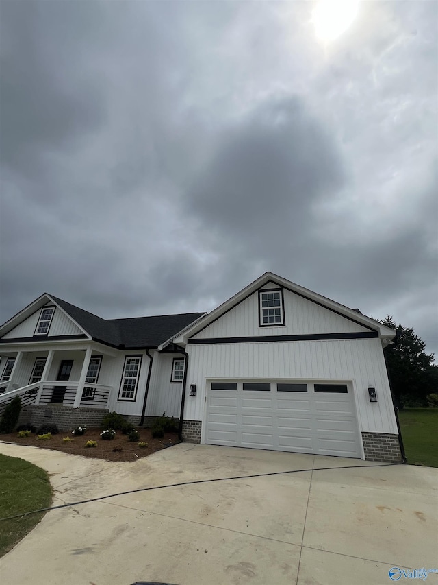 2385 Cedar Ridge Cir, Hokes Bluff, AL 35903 - view of front facade with driveway, an attached garage, covered porch, brick siding, and board and batten siding
