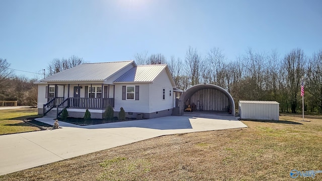 view of front of home featuring a front lawn, covered porch, and a storage unit