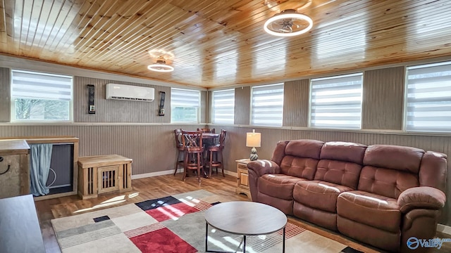 living room featuring light wood-type flooring, wood ceiling, and a wall unit AC