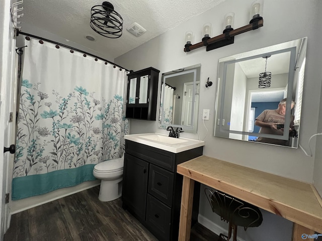 bathroom with hardwood / wood-style flooring, vanity, a textured ceiling, and toilet